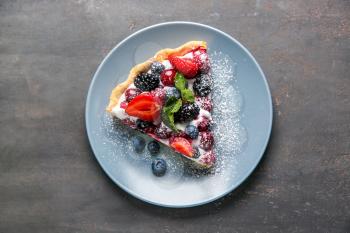 Plate with piece of delicious berry pie on table�