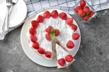 Plate with delicious strawberry cake on table, top view�