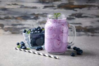 Mason jar of tasty blueberry smoothie on light table�
