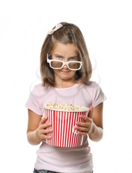 Cute little girl with cup of popcorn wearing 3D cinema glasses on white background�