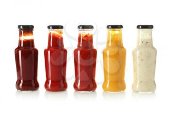 Bottles with tasty sauces on white background�
