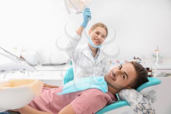 Dentist examining patient's teeth in clinic�