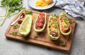 Board with meat stuffed zucchini boats on light table�