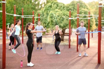 Group of sporty people training on athletic field outdoors�