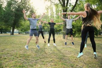 Group of sporty people training in park�