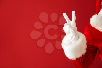 Santa Claus showing victory gesture on color background, closeup�