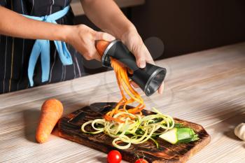 Woman making zucchini and carrot spaghetti�