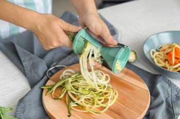 Woman making zucchini spaghetti�