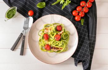 Plate with zucchini spaghetti, tomatoes and meat on light table�