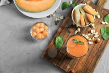 Composition with delicious melon smoothie on grey table�
