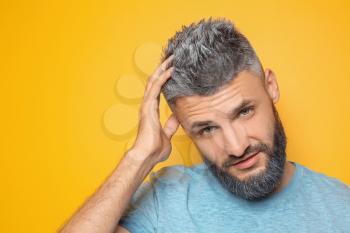 Portrait of handsome man with dyed hair and beard on color background�