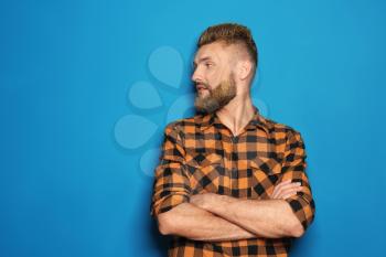 Portrait of handsome man with dyed hair and beard on color background�