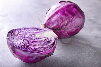 Whole and cut red cabbage on grey table�