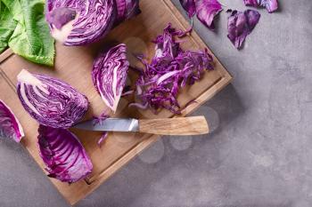 Board with sliced red cabbage on grey table�