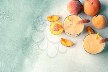 Glasses with fresh peach smoothie on light table�