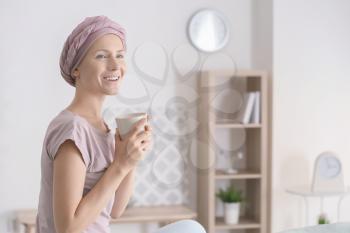 Happy woman after chemotherapy drinking tea at home�