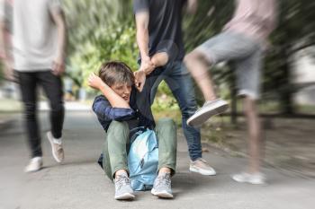 Aggressive teenagers bullying boy outdoors, view with motion blur effect�
