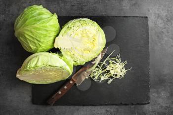 Cut fresh cabbage with knife on slate plate�