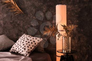 Vase with golden tropical leaves in interior of modern comfortable bedroom�
