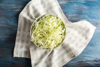 Bowl with shredded cabbage on wooden table�
