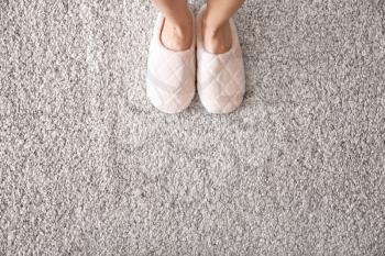 Woman in slippers standing on carpet�