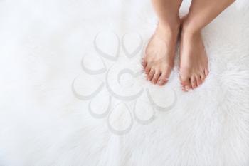 Barefoot woman standing on fluffy carpet�