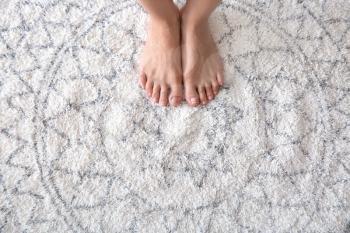 Barefoot woman standing on carpet�