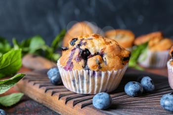 Tasty blueberry muffin on wooden board�