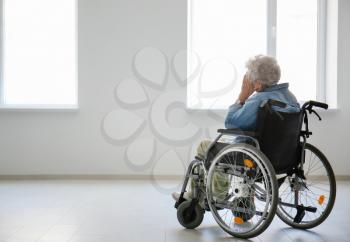 Lonely senior woman in wheelchair indoors�