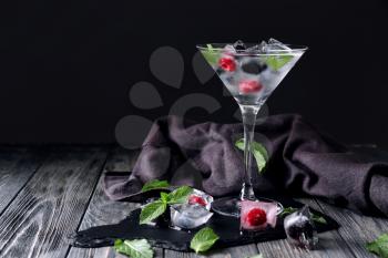 Glass of refreshing summer cocktail with berries on wooden table�
