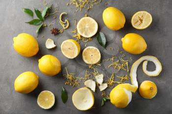 Composition with ripe lemons and fresh zest on grey background�
