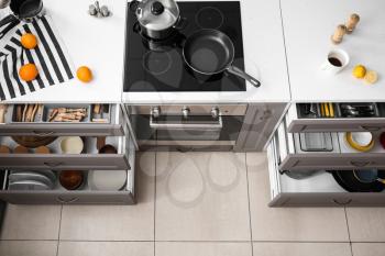 Set of clean kitchenware in open drawers�