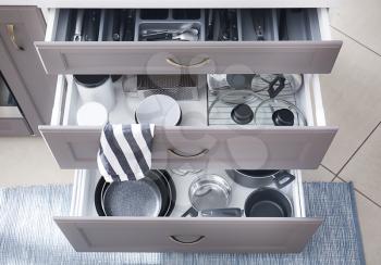Set of clean kitchenware in drawers�