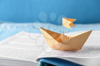 Origami boat on open book, closeup�
