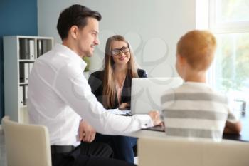 Young man and his son meeting with headmistress at school�
