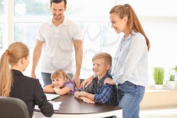 Young couple and their children meeting with headmistress at school�