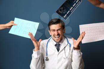 Stressed doctor on color background�