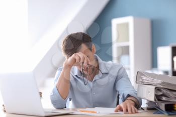 Tired businessman working in office�