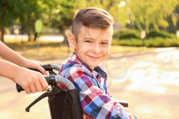 Boy in wheelchair and his sister outdoors�