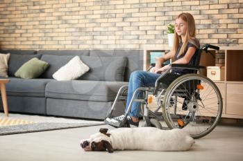 Teenage girl in wheelchair and her dog at home�