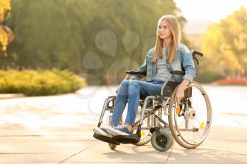 Cute teenage girl in wheelchair outdoors�