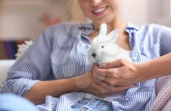 Beautiful young woman with cute rabbit at home, closeup�