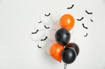 Color balloons with paper bats for Halloween party on light background�