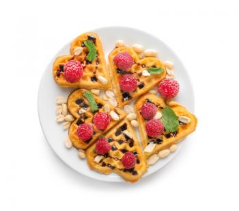 Heart shaped waffles with raspberries and nuts on white background�