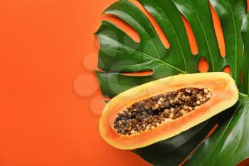 Tropical leaf and ripe fruit on color background�