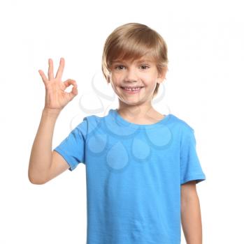 Little boy in t-shirt showing OK gesture on white background�