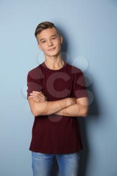 Confident teenage boy on color background�