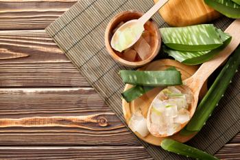Bowl and spoons with aloe vera on wooden table�