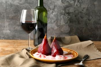 Plate with ice cream and sweet pears stewed in red wine on wooden table�