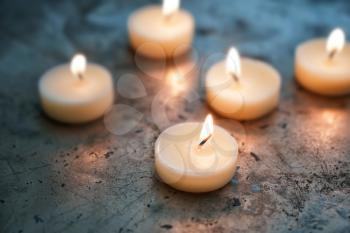 Beautiful burning candles on grey table�